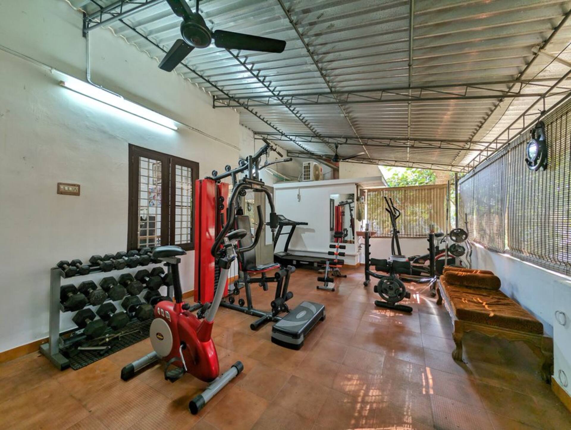 The home gym with a treadmill, stationary bike and free weights.