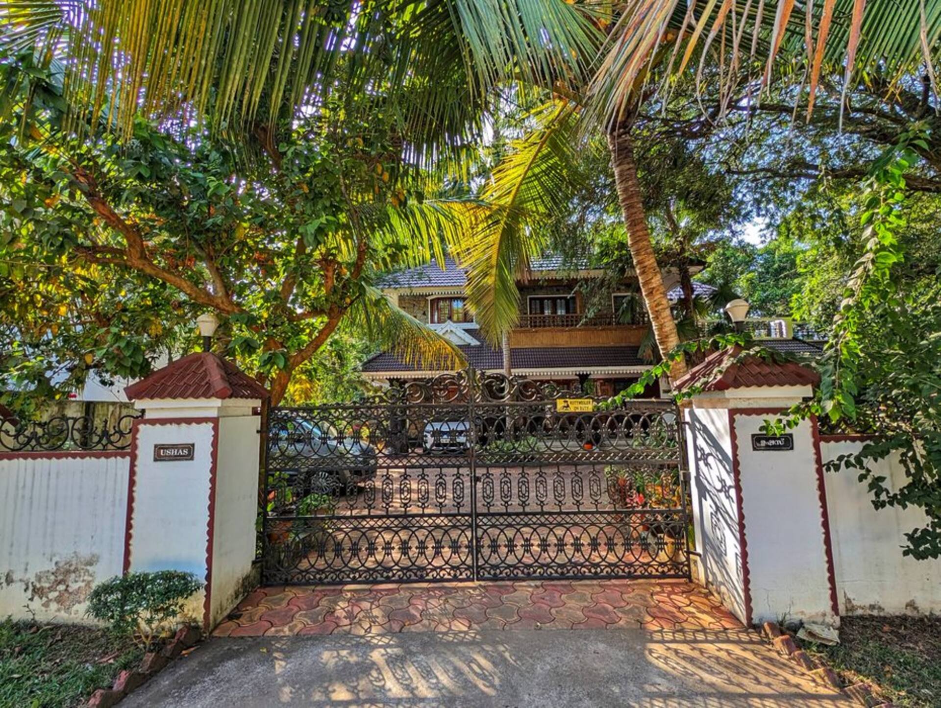 The gated entrance to the property, with the driveway leading in under the trees.